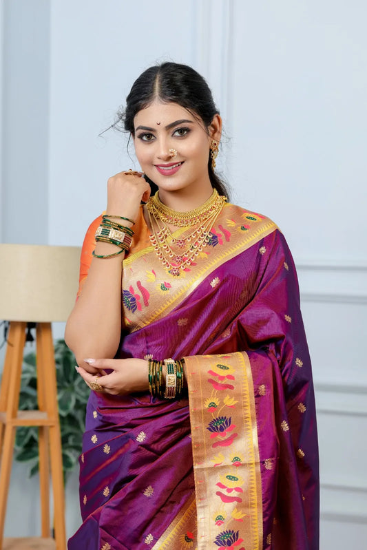 Traditional paithani saree look in royal purple silk with golden zari border, peacock and lotus motifs, styled with layered gold jewelry