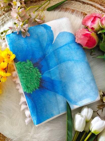 Elegant woman draped in a white linen digital print saree with blue floral design