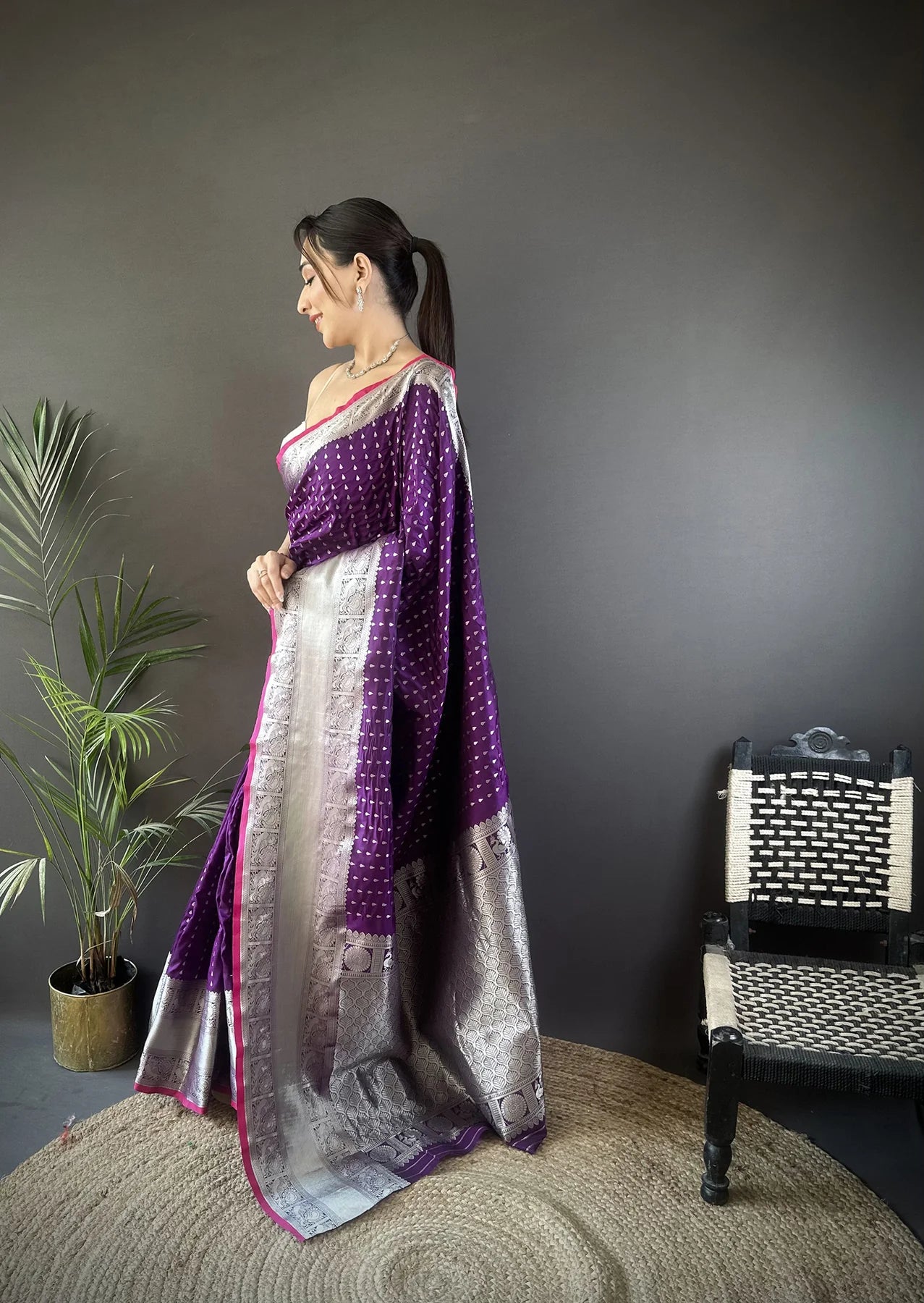 Elegant woman wearing a traditional purple Banarasi silk saree with intricate gold zari work, perfect for weddings and festive occasions.