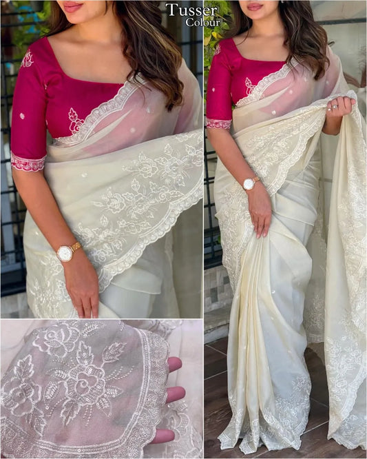 Elegant cream embroidered saree with floral lace border, paired with magenta blouse, ideal for festive and traditional occasions.