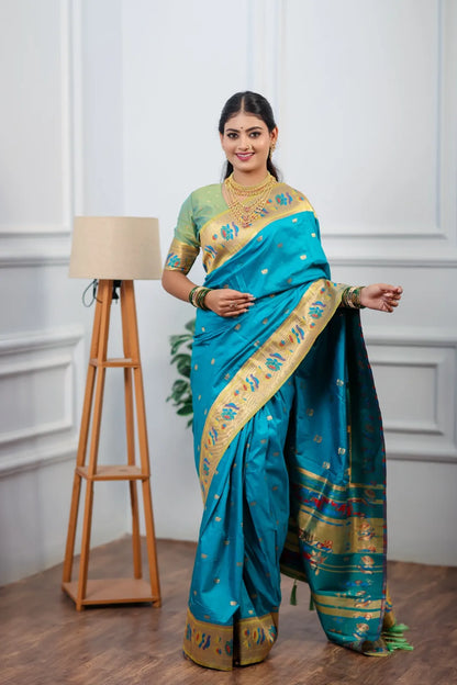 Traditional paithani saree look featuring peacock blue silk saree with golden zari border and colorful peacock motifs styled with gold jewelry