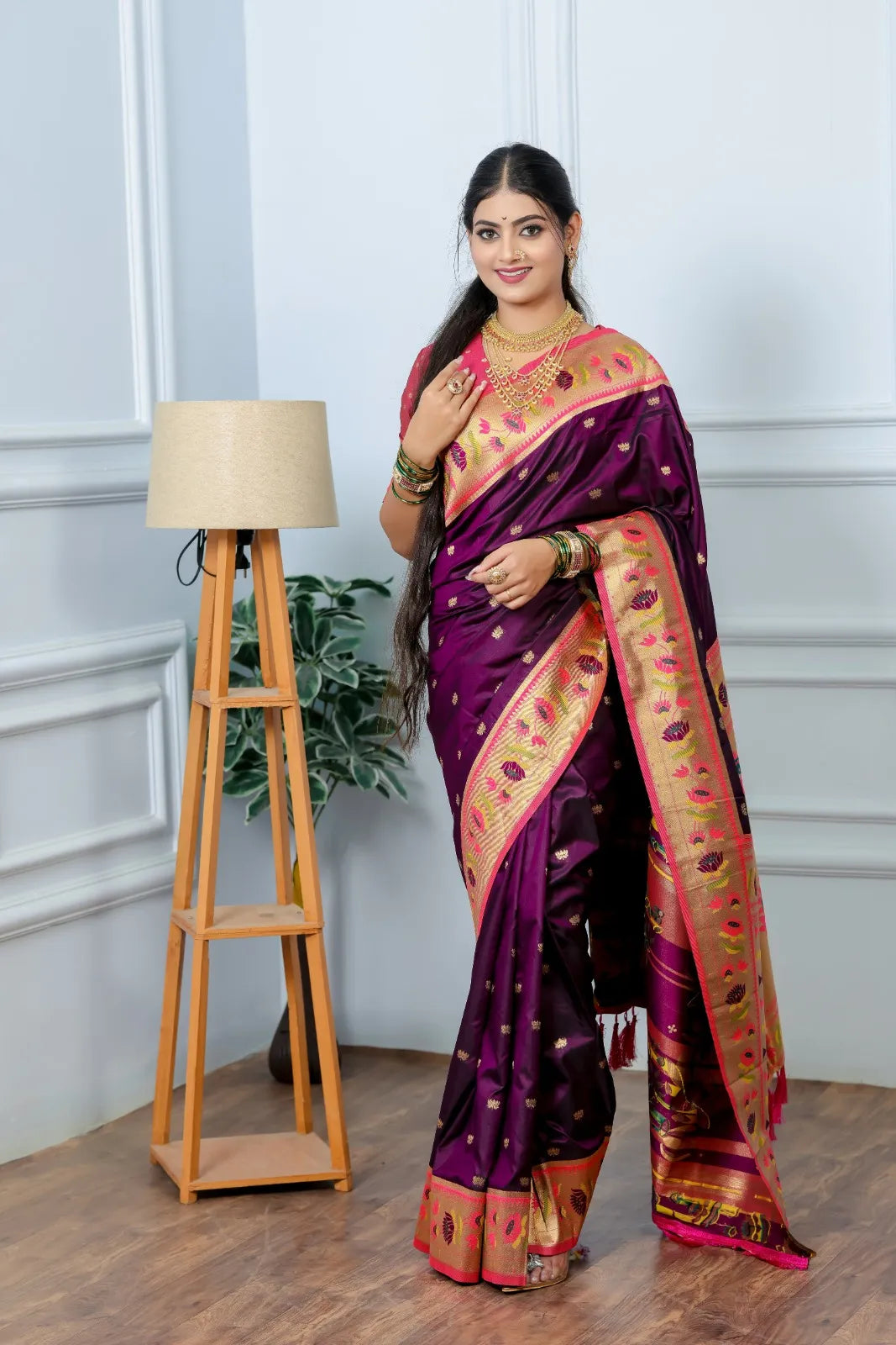 Close-up paithani saree look featuring wine purple handwoven silk with golden tissue border and multi-layered gold necklace styling