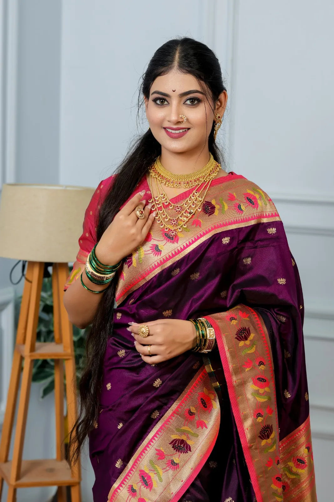 Close-up paithani saree look featuring wine purple handwoven silk with golden tissue border and multi-layered gold necklace styling