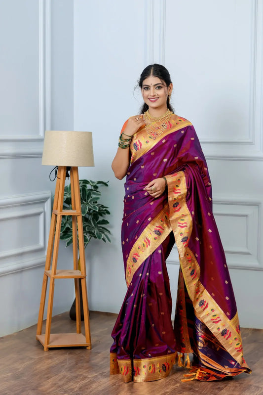 Traditional paithani saree look in royal purple silk with golden zari border, peacock and lotus motifs, styled with layered gold jewelry
