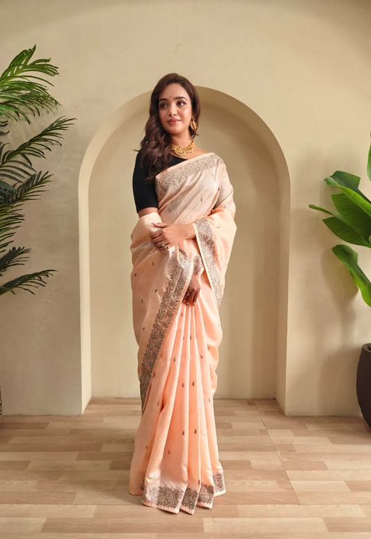 Woman wearing peach tussar saree with sequin border and black blouse in contemporary Indian style