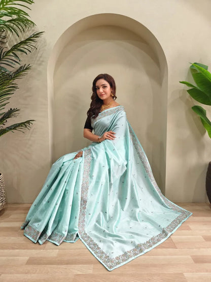 Mint blue tussar saree featuring silver sequin embroidered borders with scattered motifs paired with black elbow-length blouse and gold choker