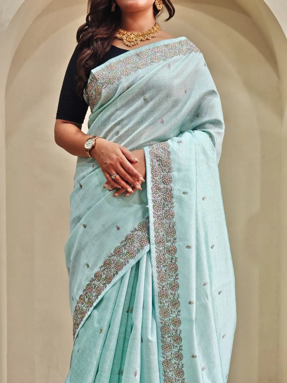 Mint blue tussar saree featuring silver sequin embroidered borders with scattered motifs paired with black elbow-length blouse and gold choker