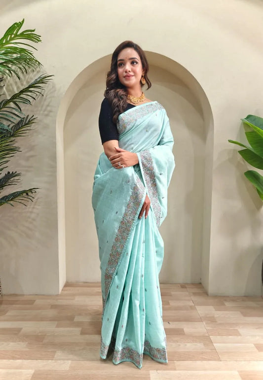 Mint blue tussar saree featuring silver sequin embroidered borders with scattered motifs paired with black elbow-length blouse and gold choker