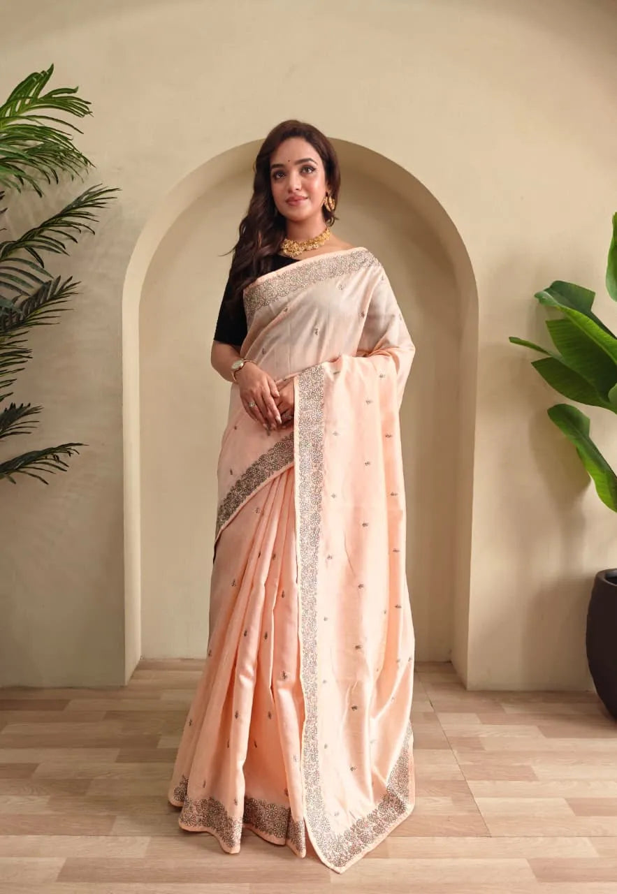 Woman wearing peach tussar saree with sequin border and black blouse in contemporary Indian style