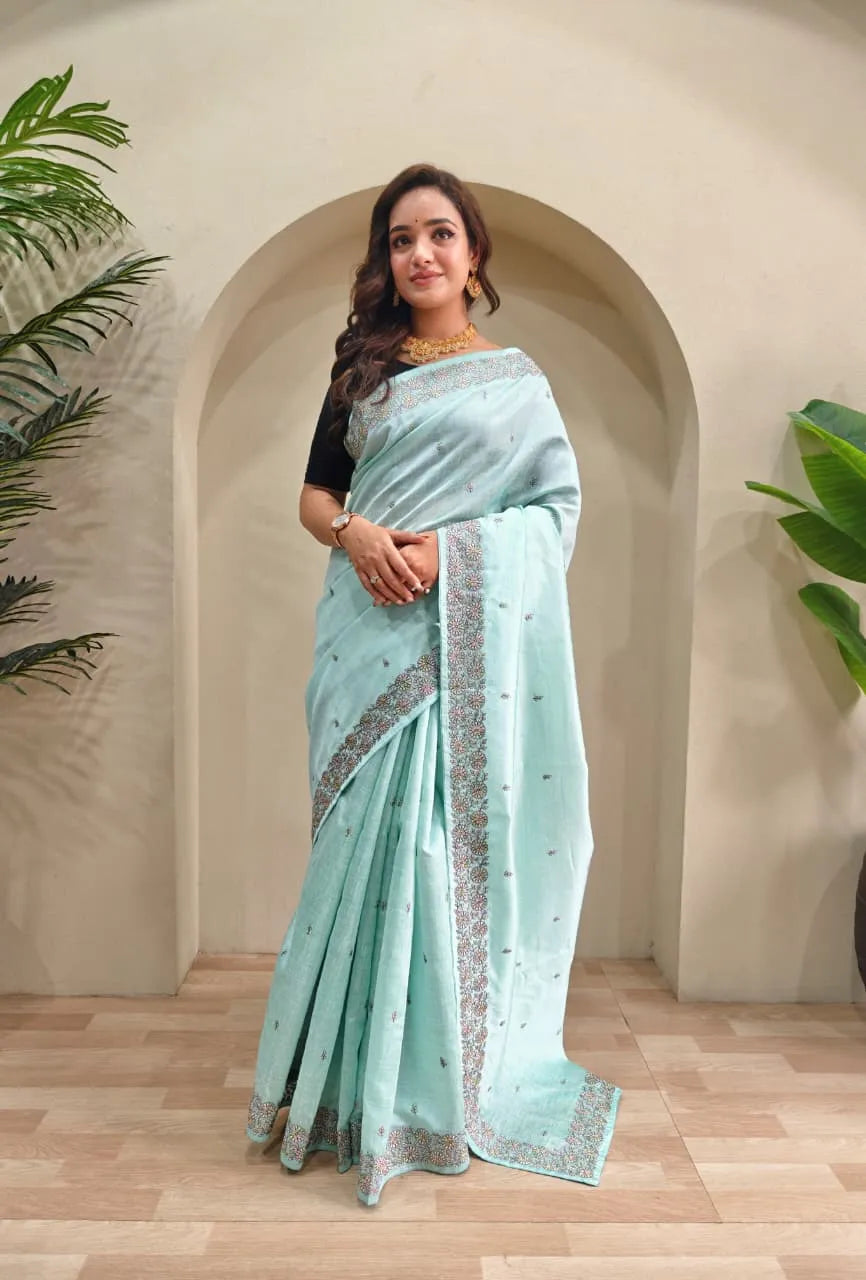 Mint blue tussar saree featuring silver sequin embroidered borders with scattered motifs paired with black elbow-length blouse and gold choker