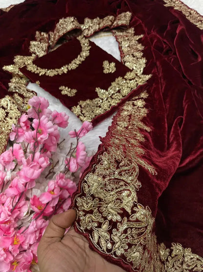 Maroon velvet celebrity style wedding saree featuring intricate gold zari work on borders and embellished three-quarter sleeve blouse